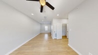 This single-story, 3-bedroom, 1-bathroom home offers a thoughtfully laid-out floor plan that maximizes every square foot. Light-toned wood-look flooring flows consistently throughout the home, creating a cohesive and contemporary aesthetic. Crisp white walls and recessed lighting brighten each room, while ceiling fans in multiple spaces provide year-round comfort.

The living and dining areas provide an open, airy feel, connecting naturally to the kitchen. The kitchen features slate-blue cabinetry with dark countertops, a stainless steel sink, and black appliances, including a refrigerator and range, alongside recessed lighting and a window that invites natural light.

Each of the three bedrooms is well-proportioned, with ceiling fans, natural light from windows, and ample closet space — including a double-door closet in one bedroom and a walk-in closet accessible from the primary bedroom. The primary bedroom is notably spacious, offering room for a full furniture arrangement.

The bathroom is finished with large-format stone-look tile in the walk-in shower, a built-in niche, mosaic tile flooring, and a vanity with a dark countertop and blue cabinetry. A dedicated laundry room with plumbing hookups adds everyday convenience. A hallway connects the key areas of the home, completing this clean and move-in-ready layout.