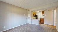 This one-bedroom, one-bathroom unit in Killeen, Texas offers a practical and well-organized layout across a single floor. The open-concept living and kitchen area serves as the heart of the home, with plush carpeting in the living space and durable wood-look flooring in the kitchen. A peninsula counter bridges the two areas, providing additional prep space and a casual dining spot. The kitchen is equipped with warm-toned wood cabinetry, light countertops, a stainless double sink, a black refrigerator, and a dishwasher, making it both functional and visually cohesive. A sliding glass door in the living area fills the space with natural light and provides direct access to a private outdoor area, fitted with vertical blinds for flexible light control. The bedroom is a comfortable, carpeted retreat featuring a ceiling fan with integrated lighting, a window with blinds, and a textured ceiling. It is complemented by a dedicated walk-in closet with built-in shelving and hanging rods, offering ample storage. The bathroom includes a full tub-shower combination with clean white tile surround. Throughout the unit, neutral tones and textured ceilings create a calm, move-in-ready atmosphere suited for comfortable everyday living.