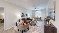 Located at 720 Verdae Blvd in Greenville, South Carolina, this single-floor residence offers a carefully considered layout with modern finishes throughout. The living room serves as the heart of the home, featuring crown molding, a ceiling fan, and a large window that invites natural light and outdoor views, creating a bright and welcoming atmosphere. A picture ledge shelf adds a personalized decorative touch above comfortable seating.

The kitchen is outfitted with rich, dark-toned shaker-style cabinetry, granite countertops, and a full suite of stainless steel appliances, including a refrigerator, electric range, and built-in microwave. Light wood-look flooring flows seamlessly through the kitchen and common areas, complementing the neutral color palette.

The primary bedroom is generously sized with plush carpeting, a ceiling fan, and large windows that frame verdant outdoor views. It connects directly to a spacious en-suite bathroom featuring a dual-sink vanity with dark wood cabinetry, granite countertops, and a well-lit mirror. The second bedroom is equally comfortable, also featuring carpeted flooring, natural light, and ample space. A secondary bathroom with tile shower and single vanity serves this area. Throughout, the design balances comfort and functionality with a clean, contemporary aesthetic.