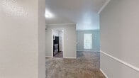 Located at 7510 Brompton Rd in Houston, TX, this one-bedroom, one-bathroom unit offers a functional and well-appointed single-floor layout. The open living area is finished with plush wall-to-wall carpeting and neutral gray walls, creating a clean and comfortable atmosphere. Crown molding adds a polished architectural detail throughout the main living space, enhancing the overall finish of the interior.

The kitchen connects to the living area via a convenient pass-through window with a breakfast bar counter, making it accessible and open. It is equipped with stainless steel appliances, including a range, microwave, and refrigerator, complemented by white cabinetry and dark hardwood-style flooring that contrasts cleanly with the light-toned countertops.

The bedroom is generously sized, featuring the same soft carpeting as the living area and a window dressed with white horizontal blinds that allows natural light to filter in while maintaining privacy.

The bathroom is neatly appointed with a single-sink vanity topped with a light quartz-style countertop, a large mirror, and a combined shower and bathtub unit. Dark hardwood-style flooring ties the bathroom's aesthetic together with the kitchen, offering a consistent design thread throughout the unit. Overall, the space presents a tidy, move-in ready environment with practical finishes.