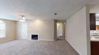 Located at 440 Cross Park Dr in Pearl, Mississippi, this single-floor residence offers a well-organized layout with comfortable living spaces throughout. The living room serves as the heart of the home, featuring a fireplace, a ceiling fan, neutral-toned walls, and plush carpeting that extends throughout the main living areas. A hallway connects the living room to the private quarters, maintaining a clear and functional flow. The kitchen is equipped with ample cabinetry featuring wood-trimmed white cabinet doors, granite-style countertops, a double-basin sink, a dishwasher, and an electric range, all set atop durable wood-look flooring. The bedrooms are generously sized, each finished with soft carpeting, neutral walls, and ceiling fans. Several bedrooms benefit from natural light through large windows, and at least one includes access to a walk-in closet. The two full bathrooms each feature a tub-shower combination, a vanity with granite-style countertops, and wood-look flooring. An arched window in one of the living areas adds an architectural detail that enhances the natural light and overall character of the space. Throughout the home, a consistent neutral color palette and practical finishes create a clean, move-in-ready environment.
