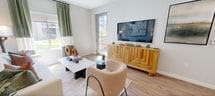 Located on S Landing Way in Tucson, Arizona, this well-designed one-bedroom, one-bathroom unit offers a thoughtfully organized single-floor layout that maximizes every square foot. Light-toned wood-style flooring flows continuously throughout the space, creating a cohesive and airy aesthetic.

The living room serves as the heart of the unit, featuring large windows dressed with two-tone green and white curtains that invite generous natural light and outdoor views. A glass door provides direct access to an outdoor area, further enhancing the bright, open atmosphere.

The kitchen is outfitted with warm wood-toned cabinetry extending to the ceiling, stainless steel appliances including a full-size refrigerator, microwave, and range, and granite-style countertops. White louvered double doors provide convenient access to an in-unit laundry or storage area nearby.

The bedroom offers a comfortable, well-proportioned retreat with a large window, wood-style flooring, and a walk-in closet. Soft, neutral tones contribute to a calm and restful environment.

The bathroom features wood-toned cabinetry, granite countertops, a combined tub and shower with glass enclosure, and continued wood-style flooring, maintaining the unit's modern and consistent design language throughout.