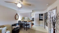 This 1-bedroom, 1-bathroom unit is thoughtfully laid out to maximize every square foot of its compact footprint. The open-concept living and dining area serves as the heart of the home, featuring a ceiling fan with a light fixture and a textured ceiling that adds subtle character to the space. A breakfast bar with seating for two connects the living area to the kitchen, creating a seamless flow ideal for both everyday living and casual entertaining. The kitchen is equipped with essential appliances, including a refrigerator, microwave, and ample cabinetry, all finished in a clean, light palette. Mirrored wall accents in the kitchen area help to visually expand the space and reflect natural light throughout. Just off the main living area, a dedicated laundry closet provides the convenience of in-unit washer and dryer connections. The neutral color scheme throughout creates a bright, airy atmosphere, while the efficient single-floor layout ensures easy accessibility across all areas of the unit. This well-appointed residence offers a practical and comfortable living environment suited for individuals or couples seeking a streamlined, low-maintenance home.
