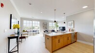 This well-appointed 2-bedroom, 2-bathroom residence at 445 South Ave E in Westfield, NJ offers a thoughtfully designed single-floor layout spanning a generous footprint. The open-concept great room seamlessly integrates the kitchen, dining, and living areas, creating a bright and connected space. The kitchen is a standout, featuring warm wood cabinetry, gleaming white quartz countertops, stainless steel appliances, and a large center island with seating, illuminated by stylish black and gold pendant lights. Large sliding glass doors and multiple windows flood the living area with natural light and provide direct access to a private balcony with outdoor views. The living room offers a comfortable, airy ambiance with light flooring and ample natural light from oversized windows. The spacious primary bedroom includes light hardwood-style flooring, a walk-in closet, and a well-sized en-suite bathroom featuring marble-style tile flooring, a glass-enclosed shower, and white cabinetry with dark countertops. The second bedroom is equally generous in size and is served by a second full bathroom appointed with marble-look tile, a vanity with white cabinetry, and a walk-in glass shower. Three closets and two hallways complete this well-organized and refined residence.