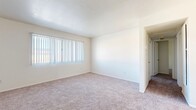 Located in Barstow, California, this single-story, 2-bedroom, 1-bathroom home offers a practical and comfortable layout across a well-utilized floor plan. The interior is finished with a neutral color palette of crisp whites and warm beige tones, creating a clean and inviting atmosphere throughout.

Both bedrooms feature plush wall-to-wall carpeting and vertical blind-covered windows that allow natural light to filter in. The spacious primary bedroom includes a sliding-door closet offering ample storage, while the second bedroom also benefits from its own window with outdoor views. A dedicated hallway closet provides additional storage convenience.

The kitchen is equipped with warm-toned wood cabinetry, a gas range, dishwasher, and a ceiling fan with light fixture overhead. Wood-look plank flooring runs through the kitchen, adding a modern and easy-to-maintain surface that contrasts nicely with the cabinetry.

The bathroom features the same wood-look flooring as the kitchen, a wood-toned vanity with sink, a mirror, and a narrow privacy window that brings in natural light while maintaining seclusion. A connecting hallway ties all rooms together efficiently.

Overall, this home presents a straightforward, functional design well-suited for comfortable everyday living in the high desert community of Barstow.