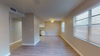 This single-floor residence offers a thoughtfully designed layout that balances open living spaces with functional, well-defined rooms. The expansive living and dining area is finished with light-toned wood-look flooring, neutral warm-beige walls, and a ceiling fan with light fixture, creating a bright and airy atmosphere. Multiple windows fitted with horizontal blinds allow generous natural light to fill the space throughout the day.

The kitchen is efficiently designed in an L-shaped configuration, featuring crisp white cabinetry, light granite-style countertops, a skylight overhead, and a full suite of stainless steel appliances including a range, microwave, dishwasher, and ample storage via a built-in pantry with bi-fold doors. The kitchen opens seamlessly toward the main living area, reinforcing the home's open feel.

The two bedrooms are carpeted for comfort, each equipped with a ceiling fan and windows with blinds that provide both natural light and privacy. The neutral gray-toned walls give each room a calm, versatile backdrop.

The bathroom is finished with beige ceramic tile surround in the tub/shower combo, a white vanity, wood-look flooring, and clean, classic fixtures. Overall, the home presents a clean, move-in-ready aesthetic with consistent finishes throughout.