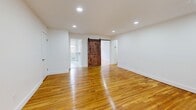 Located at 500 Adams Lane in North Brunswick, NJ, this 2-bedroom, 1-bathroom unit offers a well-planned single-floor layout with a clean, modern aesthetic throughout. Gleaming hardwood floors flow seamlessly through the living room, hallway, and both bedrooms, lending warmth and continuity to the space.

The living room is bright and welcoming, featuring recessed lighting and a window that invites natural light and outdoor views of the surrounding neighborhood. A standout rustic sliding barn door serves as a charming architectural accent, connecting rooms while adding character to the otherwise crisp, white interior.

The spacious primary bedroom benefits from dual windows providing ample natural light and a peaceful residential outlook. The second bedroom is equally well-lit with its own window and recessed lighting.

The kitchen features gleaming marble-look tile flooring, white cabinetry, stainless steel appliances, and a breakfast bar-style counter — practical and stylish. A navy accent tile backsplash ties the kitchen's design to the bathroom, creating a cohesive visual theme throughout the unit.

The bathroom is a notable highlight, showcasing bold navy elongated picket tiles on the tub surround, contrasted by classic white subway tiles and coordinating navy floor tiles, all finished with chrome fixtures and a window for natural ventilation.