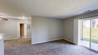 Located at 424 Spring Lake Blvd in Granger, Indiana, this single-floor, one-bedroom, one-bathroom unit offers a practical and comfortable layout. The combined kitchen and living area forms the heart of the space, with the kitchen featuring white cabinetry with wood-tone trim, light countertops, a double-basin sink, electric range, dishwasher, and refrigerator, all set over durable wood-look vinyl flooring. The living area is carpeted and bright, highlighted by a sliding glass door that opens to a view of a well-maintained green lawn, filling the space with natural light. The bedroom is a comfortable size, finished with plush carpet, neutral gray walls, a window with outdoor views, and a closet with a sliding door and built-in hanging rod. Four closets throughout the unit provide generous storage. The full bathroom includes a single-sink vanity with a large mirror, stylish vanity lighting, a soaking tub with tiled surround, and wood-look flooring. A dedicated laundry area and utility room add everyday convenience. Textured ceilings are consistent throughout, contributing to the unit's cohesive and functional design.