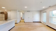 Located at 2430 S 19th St in Council Bluffs, Iowa, this well-designed single-floor residence offers a clean, contemporary aesthetic throughout its two bedrooms and two bathrooms. Light hardwood flooring flows seamlessly across the entire layout, complemented by crisp white walls and dark baseboards that create a polished contrast.

The kitchen is a standout feature, showcasing rich dark-stained cabinetry, light marble-style countertops, a peninsula with an integrated sink, and a full suite of stainless steel appliances including a refrigerator, range, microwave, and dishwasher. Recessed lighting adds a warm, functional glow to the space.

The bright and open living area benefits from multiple windows with blinds, allowing natural light to fill the room, along with a private exterior door. Both bedrooms are comfortably sized with natural light provided by windows offering outdoor views. The primary bedroom includes access to a dedicated walk-in closet outfitted with wire shelving and hanging rods for generous storage.

The two bathrooms mirror the home's consistent design language, featuring dark wood vanities, marble-style countertops, and full tub-shower combinations. Each bathroom maintains the light hardwood flooring found throughout the rest of the residence, contributing to the cohesive and modern feel of this thoughtfully designed home.