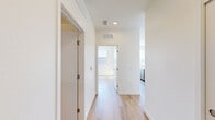 Located at 5256 Federal Blvd in Denver, Colorado, this single-floor unit offers three bedrooms and two bathrooms within a thoughtfully designed, modern floor plan. Light wood-tone flooring runs consistently throughout the space, lending warmth and visual continuity from room to room.

The open-concept kitchen and living area serves as the heart of the unit. The kitchen is outfitted with white upper cabinetry, warm wood-toned lower cabinets, a white subway tile backsplash, stainless steel appliances including a gas range, microwave, and refrigerator, and a clean white island with an integrated sink. A large window in the adjacent living area fills the space with natural light and provides open views of the surrounding Denver neighborhood.

A central hallway connects the bedrooms and bathrooms, maintaining a clean, efficient layout. The bedrooms are bright and simply finished, with large windows offering elevated views of the cityscape and distant mountains. The primary bedroom provides a comfortable footprint for everyday living.

Both bathrooms feature light wood flooring, and at least one includes a full tub-shower combination with striking marble-look tile surrounds, a built-in niche, and a wood-paneled vanity. An in-unit stacked washer and dryer is also included, adding everyday convenience to this modern Denver residence.