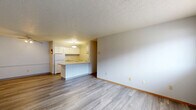 Located at 2315 Muirwood Dr in Columbus, Ohio, this single-floor residence offers a functional two-bedroom layout with a well-organized flow throughout. The living room features wood-look vinyl flooring, a ceiling fan, a textured ceiling, and a baseboard heating system, with a window that brings in natural light. Adjacent to the living area, the kitchen is designed as a galley-style space with white cabinetry lining both sides, light-toned laminate countertops, a full suite of white appliances including a refrigerator, electric range, and dishwasher, and durable wood-look flooring underfoot. A pendant light fixture illuminates the workspace efficiently. The two bedrooms are carpeted and each feature ceiling fans, textured ceilings, baseboard heating, and windows with blinds providing natural light and privacy. The primary bedroom is generously proportioned and includes access to a dedicated walk-in closet outfitted with dual wire shelving systems on both walls, offering ample storage. Throughout the unit, neutral gray tones on the walls create a clean, versatile backdrop. Wall-unit air conditioners are present in select rooms, complementing the baseboard heating for year-round climate control.