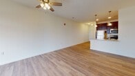 Located at 421 W Market St in Marietta, Pennsylvania, this single-floor unit offers a clean, modern design throughout its well-appointed layout. The open-concept living and dining area is bright and spacious, featuring light hardwood-style flooring, neutral white walls, and a ceiling fan that enhances airflow and comfort. A large front door with transom windows allows generous natural light to fill the living space, creating an airy and welcoming atmosphere.

The kitchen is efficiently designed with rich dark cabinetry, granite countertops, stainless steel appliances, and pendant lighting, flowing seamlessly into the main living area via a breakfast bar. A long hallway connects the living space to the private areas of the unit, with an electrical panel conveniently accessible along the way.

The bedroom features soft wall-to-wall carpeting, a ceiling fan, and a window that provides natural light and ventilation. The bathroom is finished with matching dark cabinetry, granite countertops, a large mirror, and hardwood-style flooring, maintaining a consistent aesthetic throughout the unit.

A dedicated in-unit laundry area houses a full-size washer and dryer with overhead wire shelving for added storage. The overall design is cohesive, functional, and move-in ready, making this Marietta property a practical and comfortable living space.