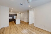Located at 3112 Leeland St in Houston's 77003 zip code, this single-floor unit offers a thoughtfully designed layout making efficient use of its compact footprint. Light wood-tone luxury vinyl plank flooring runs throughout, creating a cohesive and modern aesthetic from room to room.

The open-concept kitchen and dining area serves as the heart of the space. The kitchen is outfitted with dark espresso cabinetry, a full suite of stainless steel appliances including a French door refrigerator, range, microwave, and dishwasher, and a white quartz island with pendant lighting overhead. The dining area flows naturally into the living room, which features recessed lighting, a ceiling fan, and a wide window that brings in natural light and outdoor views.

Both bathrooms are finished to a high standard. The primary bathroom includes a dark wood floating vanity with a white quartz countertop, a large mirror, and a glass-enclosed shower. A well-organized walk-in closet with built-in shelving and hanging rods provides ample storage. Additional utility is offered through a dedicated laundry room and utility room. The hallway connects each space efficiently, maintaining an uncluttered flow throughout the unit.