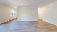 This 750 square foot apartment, situated at 530 Proudfoot Ln in London, Ontario, offers a well-designed single-floor living space. The layout comprises two bedrooms, with the primary bedroom boasting an impressive 630 square feet. Throughout the apartment, light-colored hardwood flooring creates a seamless flow and enhances the sense of space.

The rooms are characterized by crisp white walls and trim, contributing to a bright and airy ambiance. Large windows in the bedrooms and living areas allow ample natural light to flood the space, while offering pleasant views of the surrounding greenery. The apartment features modern, minimalist doors with sleek hardware, maintaining a contemporary aesthetic.

In the bedrooms, baseboard heating units are discreetly placed along the walls, ensuring comfort during colder months. The living area appears open and flexible, ideal for various furniture arrangements. While specific details about the kitchen and bathroom are not visible, the overall finish of the apartment suggests modern amenities throughout.

The property's design emphasizes clean lines and a neutral color palette, providing a blank canvas for personal decor styles. This apartment combines functionality with contemporary design, making it an attractive option for those seeking a modern living space in London, Ontario.