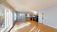 Located at 2835 N Natoma Ave in Chicago's Dunning neighborhood, this single-floor unit offers a well-designed open-concept layout finished with warm hardwood-style flooring throughout the main living areas. The expansive living and dining area is bright and airy, receiving generous natural light through large windows fitted with vertical blinds, and includes access to a private balcony. Recessed lighting adds a clean, modern touch overhead.

The kitchen is thoughtfully appointed with honey-toned oak cabinetry, dark granite countertops, and black Whirlpool appliances including a gas range, built-in microwave, dishwasher, and refrigerator. A double-basin stainless steel sink sits beneath a window, enhancing both function and natural light.

The bedrooms are well-proportioned, each featuring hardwood-style flooring, neutral gray walls, and windows that bring in ample daylight. Two full bathrooms serve the unit: one features a single-sink vanity with a tub-shower combination surrounded by beige tile, while the second offers a double-sink vanity, a large mirror, and a tiled tub-shower. Both bathrooms are finished with light tile flooring and oak cabinetry. A separate laundry area is also present within the unit.
