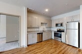 Located at 1905 Riverside Pkwy in Douglasville, GA, this single-floor 2-bedroom, 2-bathroom residence offers a well-designed, functional layout. The open-concept living and kitchen area creates a seamless flow, anchored by warm hardwood-style flooring that runs throughout the main living spaces. The kitchen is outfitted with light wood cabinetry, granite-look countertops, and a full suite of stainless steel appliances including a refrigerator, range, microwave, and dishwasher — providing both style and practicality. The living room benefits from natural light and includes a ceiling fan for added comfort. Both bedrooms are carpeted and generously sized, each featuring ceiling fans, windows with blinds that invite natural light, and access to dedicated closets equipped with wire shelving systems for organized storage. The spacious primary bedroom offers ample room for furnishings. The two bathrooms each feature hardwood-style flooring, vanities with updated cabinetry, and practical fixtures; one includes a shower-tub combination. A neutral color palette throughout the home creates a clean, move-in-ready ambiance suitable for a variety of décor styles.