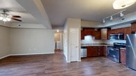 This well-appointed 2-bedroom, 2-bathroom residence in Waterloo, Iowa offers a thoughtfully designed single-floor layout that maximizes both comfort and functionality. The open-concept living, dining, and kitchen area serves as the heart of the home, featuring rich hardwood-style flooring and a tray ceiling with a ceiling fan in the living room that adds architectural character. A sliding glass door connects the living area to a covered wooden deck, ideal for outdoor relaxation.

The kitchen is well-equipped with rich cherry-toned cabinetry, granite-style countertops, and a full suite of stainless steel appliances, including a range, microwave, dishwasher, and refrigerator. A pantry provides additional storage convenience.

The spacious primary bedroom features a tray ceiling, ceiling fan, and hardwood-style flooring. The second bedroom offers plush carpet, a natural window view, and a double-door closet. Both bathrooms are clean and functional, with one featuring a full soaking tub and shower combo.

Additional highlights include an in-unit laundry area, a utility room, multiple closets throughout, and a connecting hallway that ties the layout together efficiently. The neutral color palette and practical finishes throughout create a move-in-ready environment.