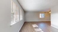 This two-story residence at 3430 Kay St in Columbia, SC offers a clean, modern interior with consistent finishes throughout. The main living areas feature durable wood-look flooring that reflects natural light streaming in through multiple windows fitted with horizontal blinds. Neutral gray walls and textured ceilings provide a bright, welcoming atmosphere across the living spaces.

The kitchen is well-appointed with white shaker-style cabinetry, granite-look countertops, a stainless steel sink, dishwasher, and refrigerator, all set atop matching wood-look flooring. A ceiling fan is present in one of the main living areas, adding both function and comfort.

The bedrooms are carpeted in neutral tones and each features at least one window with views of the surrounding greenery, allowing for ample natural light. The rooms offer generous proportions suitable for a variety of furniture arrangements.

The bathrooms are finished with wood-look flooring, white fixtures, and clean countertops. The full bathroom includes a single-sink vanity with rich dark wood cabinetry, a granite-style countertop, a large mirror, and a tiled shower-tub combination. A secondary half-bath features a white vanity and matching fixtures.

Overall, the space presents a well-maintained, move-in-ready layout with consistent, contemporary finishes throughout both floors.