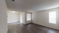 Located at 8730 N Himes Ave in Tampa, Florida, this single-floor unit offers a clean, functional layout designed for comfortable everyday living. The main living area is a generously proportioned open space finished with rich, dark hardwood-style flooring and neutral white walls, creating a bright and versatile environment. A textured ceiling runs throughout the common areas, adding subtle architectural character. A sliding glass door with vertical blinds opens the living space to an outdoor patio, allowing natural light to flow in and providing a direct connection to the exterior.

The bedrooms are carpeted for added comfort and feature windows fitted with blinds that allow for adjustable natural light. The rooms offer clean, unadorned walls with ample space for various furniture configurations.

The kitchen is equipped with white cabinetry, a granite-style countertop, and a white electric range with an overhead ventilation hood. Hardwood-style flooring continues through this space, and the layout includes access to additional utility areas. The overall design throughout the unit is straightforward and well-maintained, with a neutral color palette that lends itself to easy personalization. This single-story layout ensures easy accessibility and a cohesive flow between all living spaces.