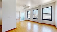 Located on the 10th floor at 537 S Spring St in the heart of Downtown Los Angeles, this 2-bedroom, 1-bathroom unit offers an efficient and well-designed layout. Warm hardwood flooring flows throughout the living spaces, complemented by crisp white walls and bold black-framed windows that frame striking city skyline views.

The open living area is bright and airy, benefiting from a tray ceiling with track lighting and an expansive feel despite its compact footprint. The kitchen features light wood cabinetry, granite countertops, stainless steel appliances including a refrigerator, electric range, and built-in microwave, along with a peninsula that connects seamlessly to the living space.

The primary bedroom is a comfortable size, offering large windows with urban views and a mirrored sliding-door closet. The second bedroom also features hardwood floors and city-facing windows, providing ample natural light. The bathroom is finished with tile flooring, a tub and shower combination enclosed in glass sliding doors, and a wood-toned vanity. The overall ambiance is clean, modern, and functional — well-suited for urban living in one of Los Angeles's most vibrant downtown neighborhoods.