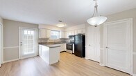 Located at 264 British Woods Dr in Nashville, TN, this two-story home offers a well-organized layout spread across two floors. The main level features a bright living room with light hardwood-style flooring, crown molding, a textured ceiling, and a standout wood-burning fireplace framed by a classic white mantel. Large windows allow natural light to fill the space. The open dining and kitchen area is equipped with white cabinetry, granite countertops, a peninsula with additional counter space, stainless steel appliances, and light hardwood-style flooring throughout. A patio provides convenient outdoor access from the main level. Upstairs, the spacious primary bedroom offers soft carpet, neutral tones, and ample closet space, while the second bedroom features a louvered double closet and a window with outdoor views. Both floors are served by dedicated bathrooms. The upper level also includes a balcony, adding additional outdoor living space. A dedicated laundry area and an abundance of closet storage — seven in total — round out this functional and comfortable home. Staircases connect both levels seamlessly, completing the practical two-story design.