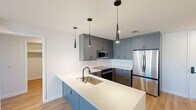 This contemporary apartment, located at 855 N Broadway in Denver, offers a well-designed living space of 940 square feet. The heart of the home is a stylish kitchen, showcasing blue cabinetry, a white subway tile backsplash, and high-end stainless steel appliances. A generously sized island with a sink provides additional prep space and casual dining options. Pendant lighting adds a touch of modern elegance.

The living areas and bedrooms feature beautiful hardwood flooring, creating a warm and inviting atmosphere. Large windows in the bedrooms and living spaces allow for ample natural light and offer views of the surrounding cityscape. The primary bedroom, measuring 140 square feet, provides a comfortable retreat.

The bathroom is equipped with a glass-enclosed shower, modern fixtures, and a sleek vanity. The apartment also includes two closets for storage and an in-unit washer and dryer for convenience. Throughout the space, clean lines, neutral walls, and minimalist design elements contribute to a contemporary aesthetic. This apartment combines functionality with style, making it an ideal urban dwelling in the heart of Denver.