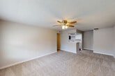 Located at 327 W Hufsmith Road in Tomball, TX, this single-floor, 2-bedroom, 2-bathroom residence offers a practical and comfortable layout designed for everyday living. The open-concept living room is generously sized, featuring plush wall-to-wall carpeting, neutral gray tones, a textured ceiling, and a ceiling fan with integrated lighting. A window at the front allows natural light to fill the space, creating a bright and welcoming atmosphere.

The kitchen flows directly from the living area and is equipped with white cabinetry, a peninsula breakfast bar, stainless steel appliances including a refrigerator, electric range, microwave, and dishwasher, along with wood-look vinyl flooring for easy maintenance.

Both bedrooms are carpeted and feature ceiling fans, windows with blinds for natural light and privacy, and closet access. The spacious primary bedroom offers a comfortable retreat, while the second bedroom is well-proportioned and versatile.

Each of the two bathrooms is appointed with a tub-shower combination, highlighted by striking marble-style wall tiling in white with gold and gray veining — a refined detail that elevates the overall aesthetic. A hallway connects the bedrooms and bathrooms, and a dedicated closet provides additional storage. The unit's clean, neutral palette throughout makes it move-in ready.