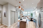 Located at 2610 109 Street NW in Edmonton, Alberta, this thoughtfully designed one-bedroom, one-bathroom residence offers a modern and efficient open-concept layout finished with light hardwood flooring and a neutral palette throughout. The combined kitchen, dining, and living area forms the heart of the home, anchored by a sleek kitchen island with a built-in sink and bar seating, illuminated by a trio of striking copper pendant lights. The kitchen features two-tone cabinetry in walnut and white, stainless steel appliances including a French door refrigerator, over-the-range microwave, and electric range, complemented by a classic subway tile backsplash and white quartz countertops. The living area is bathed in natural light from expansive floor-to-ceiling windows that frame outdoor views of the surrounding Edmonton neighbourhood. The bedroom is a serene retreat with large windows, generous closet space with double sliding doors, and direct sightlines to the main living area. The bathroom offers a clean, contemporary finish with a white vanity, full-width mirror, and light wood-look tile flooring. Additional highlights include multiple closets for ample storage and an in-suite laundry. This well-appointed residence delivers modern urban living in a bright, well-organized space.