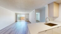 This contemporary 850 square foot apartment in Newport Beach offers a well-designed living space with two bedrooms and one bathroom. The open-concept layout maximizes the use of space, creating a seamless flow between the living areas. The apartment features beautiful hardwood flooring throughout, adding warmth and elegance to the interior.

The kitchen is a standout feature, boasting modern appliances including a stainless steel refrigerator and oven. Light-colored cabinetry and countertops contribute to a bright, airy feel. The living room is spacious and inviting, with large sliding glass doors that lead to an outdoor area, allowing for an abundance of natural light and potential outdoor views.

The primary bedroom is generously sized at 260 square feet, providing ample space for relaxation and storage. Both bedrooms feature large windows that flood the spaces with natural light. The bathroom is sleek and modern, with a clean white color scheme and updated fixtures.

Additional amenities include built-in closets with mirrored doors, ceiling fans, and air conditioning units for year-round comfort. The apartment's neutral color palette and minimalist design create a versatile canvas for various decorating styles, making it an ideal space for modern urban living in the heart of Newport Beach.