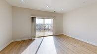 Located at 739 S 300 W in Salt Lake City, UT, this well-appointed 2-bedroom, 4-bathroom single-floor unit offers a thoughtfully designed layout with modern finishes throughout. The open-concept kitchen and living area serves as the heart of the home, featuring crisp white cabinetry, a large peninsula with a built-in sink, stainless steel appliances including a French door refrigerator and microwave, and stylish pendant lighting overhead. Light wood-tone flooring runs through the main living areas, adding warmth to the clean, contemporary aesthetic. The living room receives excellent natural light and opens directly onto a private balcony through sliding glass doors, offering open views of the Salt Lake City skyline and surrounding urban landscape. The two bedrooms are carpeted for comfort, with the primary bedroom featuring a ceiling fan, a bright window with blinds, and access to a dedicated walk-in closet with full-length hanging rods. The bathrooms are clean and functional, with tiled tub-shower combinations and wood-tone flooring. A dedicated in-unit laundry room includes a full-size washer and dryer alongside upper cabinetry for added storage. The unit combines practical amenities with modern design in a convenient urban location.