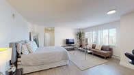 Located at 10401 Wilshire Blvd in Los Angeles, this thoughtfully designed studio unit offers an efficient and stylish single-floor layout. The open main living area seamlessly combines sleeping and lounging spaces, finished with light hardwood flooring and crisp white walls that enhance the sense of brightness and openness. Large windows allow ample natural light to pour in while framing views of the surrounding cityscape and neighboring high-rises.

The kitchen is well-appointed with rich dark cabinetry, granite countertops, stainless steel appliances including a refrigerator, gas range, and microwave, as well as a breakfast bar with modern seating — perfect for casual dining. Recessed lighting and tile flooring give the kitchen a clean, functional aesthetic.

The bathroom features a combined tub and shower enclosed with glass sliding doors, stone tile flooring, and a narrow window that introduces natural light while maintaining privacy. Its clean, minimalist design complements the overall character of the space.

Throughout the unit, the neutral color palette, light wood floors, and open configuration create a calm, modern ambiance well-suited for urban living in the vibrant Westwood neighborhood of Los Angeles.