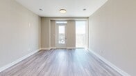 Located on the 18th floor at 195 Dundas Street in downtown London, Ontario, this modern 2-bedroom, 2-bathroom unit offers a well-designed layout with contemporary finishes throughout. Light grey laminate flooring flows seamlessly through the main living areas, complementing the neutral warm-beige walls that create a clean, cohesive aesthetic.

The kitchen is a standout feature, equipped with crisp white cabinetry, grey quartz countertops, a white subway tile backsplash, a central island with pendant lighting, and a full suite of stainless steel appliances including a French door refrigerator, electric range, built-in microwave, and dishwasher. The adjacent living area benefits from large floor-to-ceiling windows and direct balcony access, offering expansive panoramic views of the London cityscape and beyond.

Both bedrooms are well-proportioned, featuring large windows that flood the rooms with natural light and frame striking elevated city views. The primary bedroom includes a dedicated closet with wire shelving and hanging rods for organized storage. The two bathrooms are finished with grey quartz vanities and tile flooring; one features a soaker tub with elegant marble-style surround tiles. The unit's high-floor position ensures impressive, unobstructed sightlines across the city.