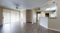 Located at 6239 Love Dr in Irving, Texas, this single-story, 3-bedroom, 2-bathroom home offers a well-designed layout with a comfortable and functional living environment. The open living area features rich wood-style laminate flooring, crown molding, and a ceiling fan, creating a bright and welcoming atmosphere. Vertical blinds along the sliding glass door allow for natural light control and outdoor access. The kitchen is positioned adjacent to the living space and features a wraparound breakfast bar peninsula, white cabinetry, white appliances, and a skylight that brings in additional natural light — ideal for both everyday meals and casual entertaining. The primary bedroom is generously sized, finished with plush carpet, and includes a walk-in closet with wire shelving for ample storage. The two bathrooms are finished with wood-style flooring, white cabinetry with gray countertops, large mirrors, and tub-shower combinations with tile surrounds. Secondary bedrooms are carpeted and include closets with wire shelving systems. A dedicated in-unit laundry space with washer and dryer hookups adds everyday convenience. Throughout the home, a neutral warm beige palette and consistent finishes create a cohesive and move-in-ready feel.