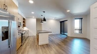 Located at 1350 40th St in Denver's vibrant Cole neighborhood, this thoughtfully designed one-bedroom, one-bathroom unit offers a contemporary living experience with high-quality finishes throughout. The open-concept living and kitchen area is anchored by warm wood-look luxury vinyl plank flooring, recessed lighting, and a central kitchen island with a dark countertop and striking black pendant lights overhead. The kitchen is well-appointed with light wood cabinetry, a bold blue subway tile backsplash, stainless steel appliances including a gas range, built-in microwave, refrigerator, and dishwasher, as well as a gold-toned pull-down faucet. The living area benefits from abundant natural light through floor-to-ceiling sliding glass doors that open to an outdoor area, complemented by an additional side window. The bedroom features plush carpeting, a ceiling fan, and a window with outdoor views. A spacious walk-in closet with built-in shelving and hanging rods provides ample storage. The bathroom is elegantly finished with a wood-toned vanity, dark countertop, black hardware accents, and a glass-enclosed walk-in shower with dark vertical tile, completing this modern and cohesive living space.