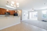 This single-floor residence offers a thoughtfully designed layout that balances comfort and functionality throughout. The open-concept kitchen and living area serves as the heart of the home, where rich cherry wood cabinetry, granite countertops, and black appliances create a polished culinary space. A breakfast bar with pendant lighting above and a chandelier-lit dining area nearby make entertaining effortless, while tile flooring flows seamlessly underfoot. The living area extends generously, accented by crown molding, a ceiling fan, and abundant natural light streaming through large windows fitted with blinds that frame pleasant outdoor views of the surrounding community.

The bedrooms are carpeted for comfort and feature crown molding, ceiling fans, and multiple windows that invite natural light. Spacious closets with built-in wire shelving and hanging rods provide excellent storage. The bathrooms are finished with warm wood vanities, granite countertops, and tile flooring, offering a clean and cohesive aesthetic. Multiple towel bars add practical convenience throughout.

Neutral warm tones on the walls throughout the space create a bright, welcoming atmosphere that is easy to personalize. The overall design reflects a practical yet refined character, making this a comfortable and well-equipped single-floor home.
