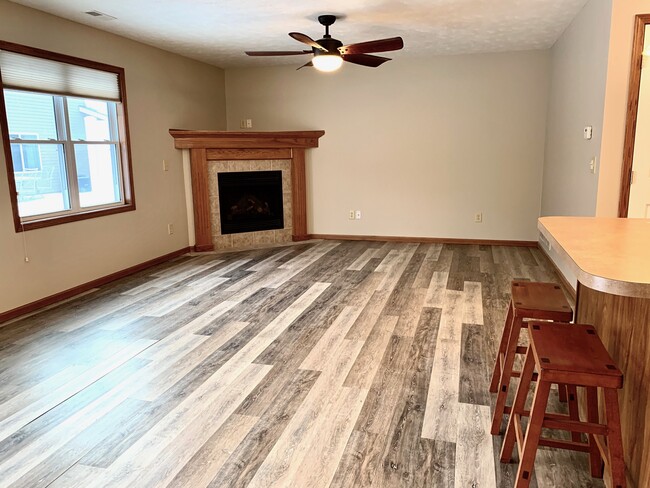 Spacious living room with cozy fireplace and new luxury vinyl plank flooring - 3611 McLaughlin Dr.