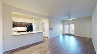 This well-appointed 3-bedroom, 3-bathroom residence at 349 Campus Cove in Wilmington, NC offers a thoughtfully designed single-floor layout. The open-concept living and kitchen area is a central highlight, featuring durable hardwood-style flooring, a ceiling fan, and French doors that lead to a private balcony, filling the space with natural light. The kitchen is equipped with rich dark-espresso cabinetry, black appliances including a refrigerator, electric range, and built-in microwave, complemented by light countertops and a breakfast bar that opens to the living area. A stacked washer/dryer unit is conveniently located nearby. Each of the three bedrooms is carpeted and outfitted with a ceiling fan, and the primary bedroom features a spacious walk-in closet with wire shelving for ample storage. The additional bedrooms include their own closets and are served by well-appointed bathrooms, each featuring dark wood vanities, white countertops, a tub/shower combo, and hardwood-style flooring. The clean, neutral color palette throughout creates a bright and cohesive aesthetic, making this Wilmington residence a functional and comfortable home.