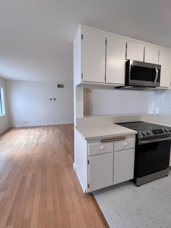 Sala de estar y comedor abiertos con cocina de paso, ideal para el entretenimiento o la vida diaria. - 11639 Chenault St