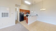 Located at 101 Palisades Dr in Lincolnton, NC, this well-appointed 2-bedroom, 2-bathroom single-floor home offers a comfortable and functional layout. The living room is bright and airy, featuring plush carpeting, soaring ceilings, a ceiling fan, and French doors that invite natural light and outdoor views. Adjacent to the living area, the dining space is accented by elegant pendant lighting and a chandelier, with light tile flooring extending into the kitchen. The kitchen is well-equipped with rich wood cabinetry, granite countertops, a full suite of black appliances, and additional pendant lighting overhead. Both bedrooms are generously sized with soft carpeting and large windows that provide ample natural light and neighborhood views. The spacious primary bedroom connects to a well-appointed en-suite bathroom featuring a dual-sink vanity with granite countertops, rich wood cabinetry, and tile flooring. Each bedroom benefits from walk-in closets with wire shelving systems for organized storage. A dedicated laundry room with utility connections and overhead shelving adds everyday convenience. Throughout the home, warm neutral tones and consistent finishes create a cohesive and inviting ambiance.