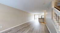 Located at 1929 Opal Street in Reynoldsburg, Ohio, this multi-level home spans three floors and offers a thoughtfully organized layout with 2 bedrooms and 3 full bathrooms. The entry-level floor features a welcoming living room with light gray walls, neutral-toned luxury vinyl plank flooring, and a staircase that connects all three levels. The main living floor includes an open-concept kitchen and living area, where white cabinetry, dark granite countertops, a peninsula island, and stainless steel appliances create a functional and attractive space. Light vinyl plank flooring continues throughout, and windows allow natural light to fill the room. A bathroom with white cabinetry and dark countertops is also found on this level. The upper floor is home to the two bedrooms, each featuring plush carpeting, vaulted ceilings, and windows that invite natural light. The primary bedroom includes a sliding closet and a ceiling fan. Bathrooms throughout feature clean white finishes, including a tub-shower combo and updated vanities. A utility room and ample storage complete the interior. Outdoors, a private patio area is enclosed by a dark wood fence with green landscaping, offering a quiet retreat within the residential neighborhood.