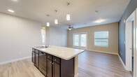 Located at 1420 S Tyler Ave in Loveland, CO, this single-floor, 3-bedroom, 2-bathroom home offers a well-designed layout that maximizes functionality and comfort. The open-concept kitchen and living area serves as the heart of the home, featuring a central island with a granite-look countertop, an integrated sink, and pendant lighting overhead. Dark espresso cabinetry pairs with a tile backsplash and black appliances, including a range, microwave, and refrigerator. The kitchen flows seamlessly into the living room, which is brightened by French doors and multiple windows that invite natural light. Durable wood-look plank flooring spans the main living areas, while ceiling fans provide year-round comfort. The bedrooms offer a cozy retreat, with the primary bedroom featuring dual windows, plush carpet, and its own ceiling fan. The additional bedrooms are similarly carpeted and well-lit. The bathrooms are finished with matching dark cabinetry, granite-look countertops, and a tiled tub-shower surround. A dedicated laundry room with a full-size washer and dryer adds everyday convenience. With built-in shelving and a closet rounding out the storage options, this home delivers a practical and polished living experience in the heart of Loveland.