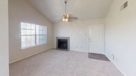This single-story space offers a cohesive, move-in-ready layout with a clean, neutral palette and consistent finishes throughout. The living room serves as a welcoming focal point, anchored by a tiled fireplace with a dark surround and complemented by vaulted ceilings, plush carpeting, and a ceiling fan with a light fixture. Natural light filters in through large windows, enhancing the open, airy feel of the space.

Adjacent to the living area, the dining space features rich wood-look flooring, a hanging chandelier, and a sizable window that brings in additional natural light, creating a pleasant atmosphere for everyday meals. The galley-style kitchen is well-appointed with dark shaker-style cabinetry, brushed nickel hardware, granite-look countertops, a white subway tile backsplash, and stainless steel appliances, offering both style and function.

The bedrooms are carpeted for comfort and each includes a walk-in closet, providing generous storage. The full bathroom is finished with wood-look flooring, a granite-topped vanity with dark cabinetry, and a full tub-shower combination with white tile surround and brushed nickel fixtures, maintaining the consistent modern aesthetic found throughout the space.