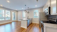 Located at 199 Dickenson St in Columbus, OH, this thoughtfully designed one-bedroom, one-bathroom unit offers a modern and efficient layout across a single floor. The open-concept living and kitchen area serves as the heart of the space, anchored by a central island with a granite countertop, an undermount sink, and stylish matte black pendant lighting overhead. The kitchen is equipped with stainless steel appliances, including a refrigerator, range, and dishwasher, complemented by white shaker-style cabinetry, a subtle tile backsplash, and additional granite countertops. Light hardwood-style flooring runs throughout the main living area, enhancing the bright and airy feel created by multiple windows with blinds. The bedroom offers plush carpeting underfoot and features generous natural light from dual windows, creating a calm and comfortable retreat. A dedicated closet provides convenient storage. The bathroom is elegantly finished with large-format marble-look tile flooring, a granite-topped vanity with a framed mirror, matte black fixtures, and a full bathtub and shower combo. Clean white walls and crisp trim work throughout the unit contribute to a cohesive, contemporary aesthetic that is both functional and visually appealing.