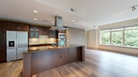 Located at 2121 North Westmoreland Street in Arlington, VA, this well-appointed 2-bedroom, 2-bathroom single-floor residence offers a thoughtfully designed open layout. The combined kitchen and living area serves as the heart of the home, showcasing rich dark wood cabinetry, granite countertops, a large center island with a statement stainless steel range hood, tile backsplash, and stainless steel appliances including a double wall oven and French door refrigerator. Recessed lighting and hardwood flooring flow throughout the main living space, which is bathed in natural light from expansive floor-to-ceiling windows and a sliding glass door that opens to a balcony with lush tree views. The primary bedroom features plush carpeting and a large window framing verdant greenery, while the en-suite bath offers travertine tile flooring, a soaking tub, glass-enclosed shower, and access to a custom walk-in closet with built-in shelving. The second bedroom is carpeted with warm accent walls. A second full bathroom includes a glass-enclosed shower and tile flooring. A hallway utility area conveniently houses an in-unit washer and dryer. Two closets provide ample storage throughout this refined Arlington residence.