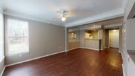 Located at 2752 Gaston Ave in Dallas, TX, this single-floor residence offers a well-designed layout that balances open living spaces with functional private rooms. The main living area is a standout feature, showcasing rich, dark hardwood-style flooring that flows throughout the common spaces, complemented by crown molding and a ceiling fan that adds both style and comfort. Track lighting and a large mirror accent the living area, enhancing the sense of openness and brightness.

The kitchen is designed for efficiency, featuring a galley-style layout with white cabinetry, granite-look countertops, a full suite of white appliances, and ample storage. A pass-through counter connects the kitchen to the living space, making it ideal for everyday use.

An adjacent area includes built-in shelving and cabinetry, providing additional storage and a natural transition to the exterior door, which allows for natural light to fill the space. The bedrooms are carpeted for comfort and include windows with blinds that offer views of the surrounding greenery.

The bathrooms are clean and functional, featuring white cabinetry, granite-look countertops, tiled tub-shower combinations, and hardwood-style flooring. Each bathroom is finished with practical storage solutions overhead. The overall ambiance of the space is neutral, move-in ready, and well-maintained.