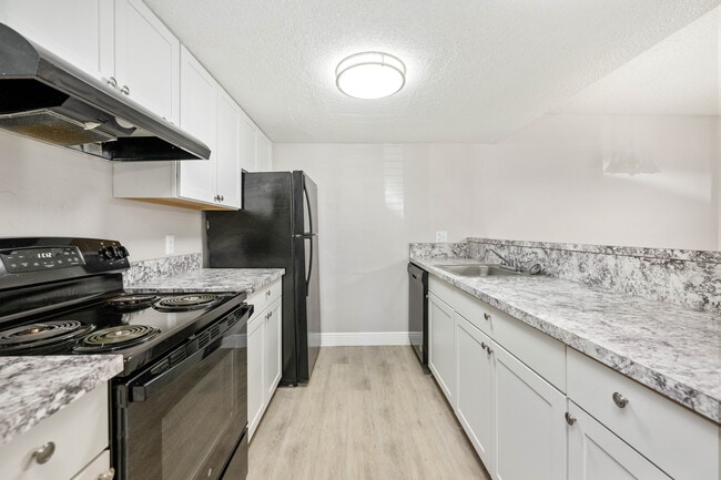 Modern kitchen with elegant white cabinetry, sleek countertops, and energy-efficient appliances. - Vista North