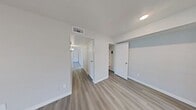 This single-story residence in Dallas, Texas, offers 730 square feet of efficiently designed living space. The home features three bedrooms, including a spacious 150 square foot primary bedroom, and two full bathrooms. Throughout the property, modern grey wood-look flooring creates a cohesive and contemporary aesthetic.

The living areas are characterized by their bright and airy ambiance, thanks to large windows that allow natural light to flood the spaces. Ceiling fans in the bedrooms provide additional comfort and air circulation. The bathrooms are outfitted with clean, white fixtures and tiling, maintaining a fresh and hygienic appearance.

The property's layout includes a hallway for easy navigation between rooms, two closets for storage, and a living room that likely serves as the central gathering space. Sliding glass doors in one of the rooms offer access to an outdoor area, expanding the living space and connecting the interior with the exterior.

The neutral color palette, predominantly featuring white walls, contributes to the home's modern feel and provides a blank canvas for personalization. Despite its compact size, the thoughtful design of this Dallas home maximizes functionality and comfort in an urban setting.