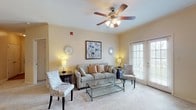 This single-story residence at 10900 E Taylor Rd in Gulfport, Mississippi, offers a thoughtfully designed layout with distinct living spaces that flow naturally from one area to the next. The living room serves as the heart of the unit, featuring warm neutral walls, plush carpeting, crown molding, and a ceiling fan with light fixture. A set of French doors fills the room with natural light and provides outdoor access, creating an open, airy atmosphere. Adjacent to the living area, the dining space accommodates a full dining set beneath a pendant light fixture, with crown molding continuing the refined aesthetic throughout.

The galley-style kitchen is efficiently arranged with ample cabinetry, white countertops, a double sink, and full appliances including a range and refrigerator. Wood-look flooring runs through the kitchen and bathrooms, providing a practical contrast to the carpeted living and sleeping areas.

The bedrooms are generously proportioned with neutral carpeting and sufficient wall space for varied furniture arrangements. Two bathrooms serve the unit — one featuring an extended vanity with wood cabinetry and a tub/shower combination, and a second with a single-sink vanity — both finished with wood-look flooring and ample storage.