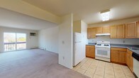 Located at 51 Rockwood Cir in Middletown, NY, this single-floor residence offers a well-organized layout designed for comfortable everyday living. The kitchen is thoughtfully equipped with warm honey-toned cabinetry, dark granite-style countertops, tile flooring, and a full suite of white appliances including a gas range, refrigerator, and dishwasher. A skylight and overhead lighting keep the space bright and functional. The kitchen flows naturally into a dining area outfitted with a ceiling fan and a window overlooking the surrounding landscape. The spacious living room features soft wall-to-wall carpeting and a large sliding glass door that opens onto a private balcony, filling the room with natural light and providing pleasant outdoor views. The bedrooms are carpeted and finished in neutral tones, with multiple windows allowing natural light to filter in; one bedroom includes a wall-mounted air conditioning unit and a closet. Baseboard heating is present throughout the unit. The full bathroom features tile flooring, a tiled tub-and-shower combination, and a window that brings in natural light. Overall, the unit presents a clean, neutral palette with practical finishes suited for a variety of living arrangements.