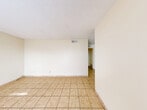 Located at 1505 La Fonda Dr in Las Cruces, New Mexico, this single-story 2-bedroom, 1-bathroom home offers a practical and straightforward layout. Light beige ceramic tile flooring runs consistently throughout the entire home, lending a cohesive and easy-to-maintain aesthetic. Textured ceilings complement the neutral cream-toned walls, creating a bright and clean interior.

The living room is an open, airy space with ample room for comfortable furnishings. Adjacent to it, the dining area provides a natural transition toward the kitchen. The galley-style kitchen is well-equipped with white cabinetry extending to the ceiling for generous storage, a gas range, a full-size refrigerator, a single-basin sink, and a window that allows natural light to brighten the workspace.

The two bedrooms are modest and functional, each featuring windows that bring in outdoor views and natural light. The primary bedroom includes a bi-fold closet and access to additional storage space. Notably, the home features five closets in total, offering exceptional storage throughout. A hallway connects the main living areas to the private quarters.

The bathroom is equipped with a full tub-and-shower combination, framed by floor-to-ceiling beige tiles, a grab bar, and a toilet — simple and functional in design. Overall, this home provides a no-frills, move-in-ready living environment suited for those seeking efficient, comfortable living in Las Cruces.